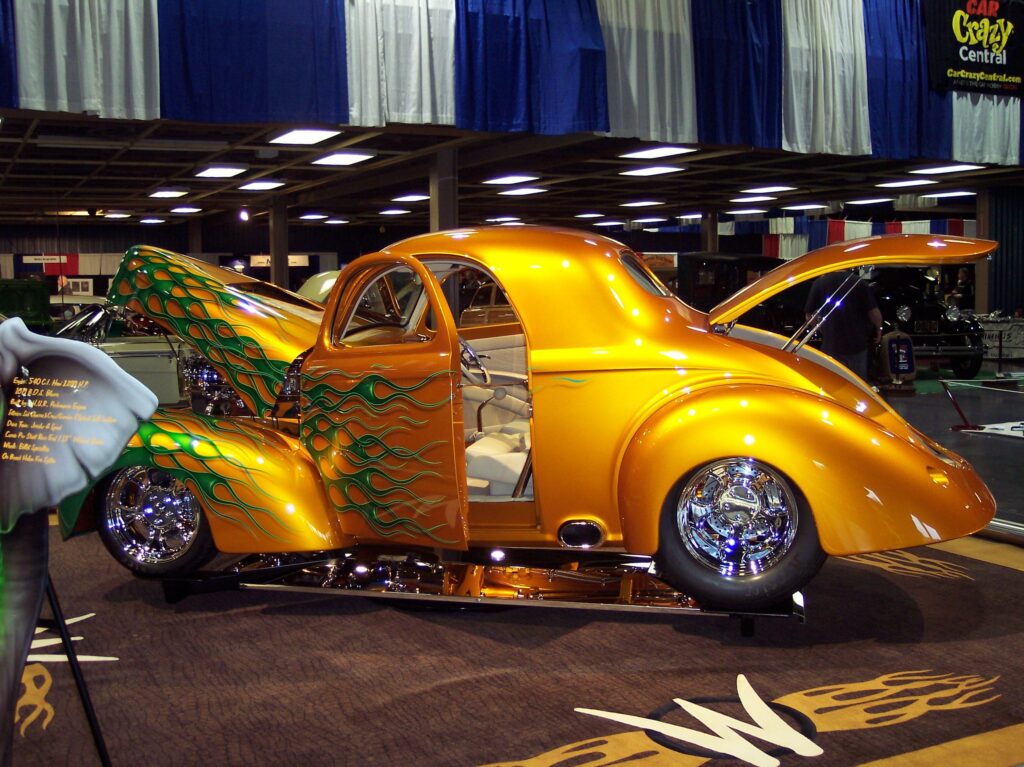 Custom orange car with open doors displayed.