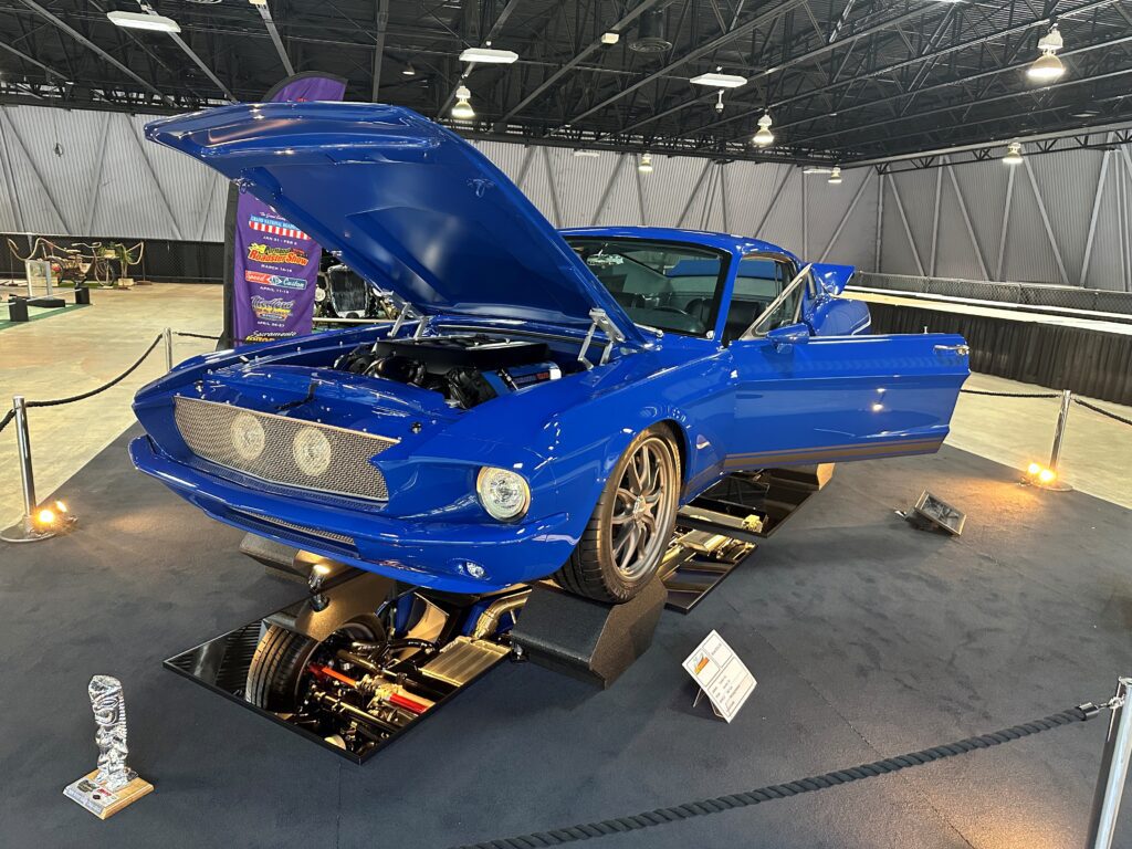 Blue classic car on display, hood open
